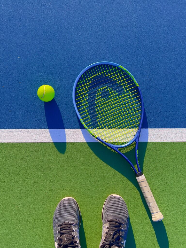 blue tennis racket on the court with a tennis ball.